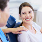 Brunette woman in a dental chair smiles because she is relaxed at the dentist
