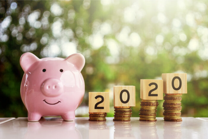 A pink piggy bank next to 2020 on coins to indicate your dental insurance benefits this year