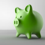 Green piggy bank on a gray counter for a post about the Dental Savings Plan at Optima Dental Spa